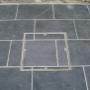 Terrasse en dalles de pierre bleue belge adoucie 60x40x3 cm posées au traditionnel à Namur. Joints hydrofuges sans retrait pour une finition durable.
