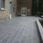Terrasse en dalles de pierre bleue belge adoucie 60x40x3 cm posées au traditionnel à Namur. Joints hydrofuges sans retrait pour une finition durable.